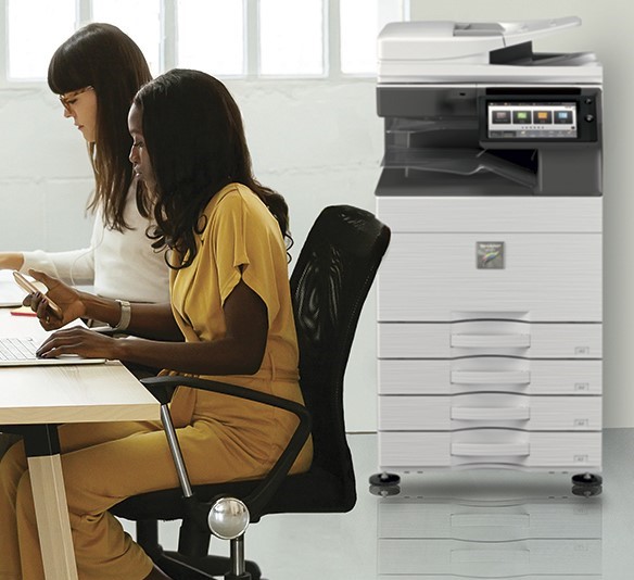 A Sharp a3 colour photocopier in office workspace